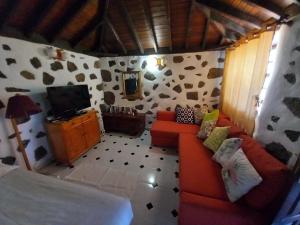 ein Wohnzimmer mit Sofa und Fernseher in der Unterkunft La Carpintera in Tijarafe