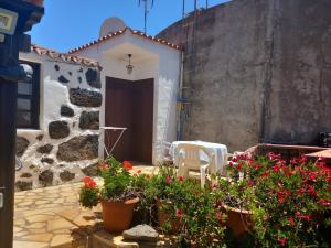 ein mit Blumen bewachsener Innenhof vor einem Haus in der Unterkunft La Carpintera in Tijarafe