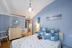 a bedroom with blue walls and a bed with a dog sitting on it at Mansarda Dei Pescatori in Imperia