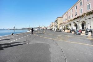 a person walking down a street next to the water at Mansarda Dei Pescatori in Imperia