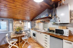 a kitchen with white cabinets and a wooden ceiling at Mansarda Dei Pescatori in Imperia