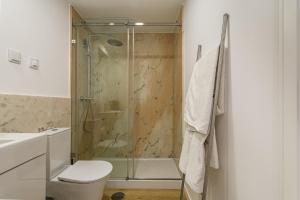 a bathroom with a shower and a toilet and a sink at Beach House In Sesimbra in Sesimbra +19 photos