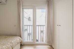 a bedroom with a bed and a large window at Beach House In Sesimbra in Sesimbra