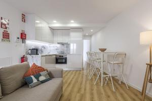 a living room with a couch and a kitchen at Beach House In Sesimbra in Sesimbra