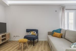 a living room with a couch and a chair at Beach House In Sesimbra in Sesimbra