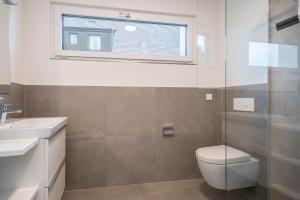 a bathroom with a toilet and a sink and a window at Ferienwohnung Arguna in Langenargen +19 photos