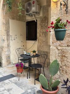 a patio with a table and chairs and plants at Il Cortile Magico in Syracuse +30 photos