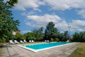 a swimming pool with lounge chairs and a blue sky at Casale I Cascetti in Piancastagnaio