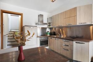 a kitchen with wooden cabinets and a vase with a plant at Mini House Valle d'Aosta in Roisan