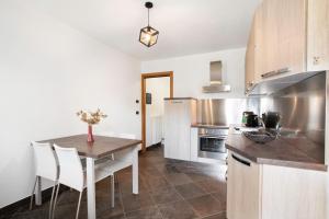 a kitchen with a table and a kitchen with a refrigerator at Mini House Valle d'Aosta in Roisan