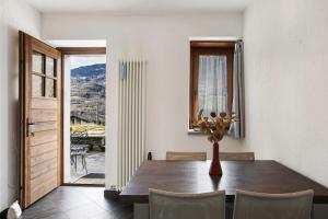 a dining room with a table and chairs and a window at Mini House Valle d'Aosta in Roisan