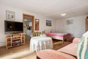 a living room with a couch and a tv at Ferienbungalows Werner in Koserow