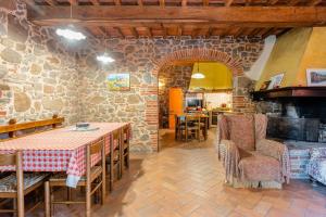 a room with a table and chairs and a stone wall at Mulino di Beboli in Lamporecchio