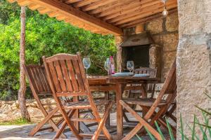 a wooden table with two chairs and a table with wine glasses at Son del Rio Vell in Pollença