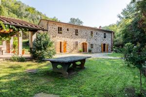 a stone house with a picnic table in the yard at Mulino di Beboli in Lamporecchio