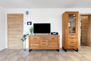 a living room with a television on a wooden dresser at Haus Morgensonne in Weilheim +19 photos