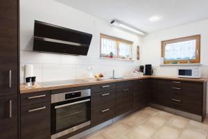 a kitchen with brown cabinets and a tv on the wall at Haus Morgensonne in Weilheim