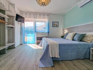 a bedroom with a bed and a large window at Casa Diamante Blu Mare in Marina di Campo