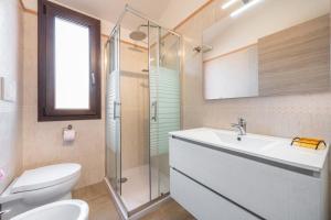 a bathroom with a toilet and a sink and a shower at Villa Gloma in Capoterra +16 photos