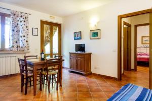 a dining room with a table and chairs and a bedroom at Bilo Gardenia in Marina di Grosseto