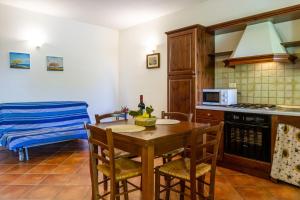 a kitchen with a table and chairs and a kitchen with a microwave at Bilo Gardenia in Marina di Grosseto