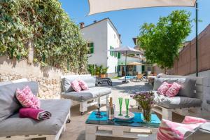a patio with couches and a table with pillows at Can Xeliu in Sóller