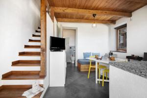 a kitchen and living room with a staircase and a table at Nature House Custu Giancu in Cichero +20 photos