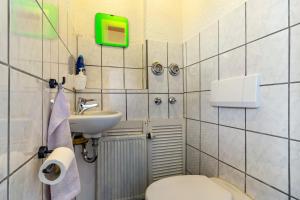 a small bathroom with a toilet and a sink at Haus Monterosa in Baden-Baden +12 photos