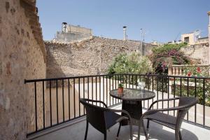 a patio with a table and chairs on a balcony at Casa Sant Sebastia in Pollença