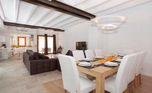 a dining room with a table and white chairs at Casa Sant Sebastia in Pollença