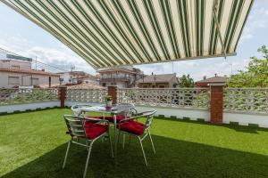 a patio with a table and chairs under a canopy at Apartamento Villa Mercedes in Rubí