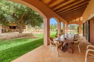 an outdoor patio with a wooden table and chairs at Casa Campillos in Llucmajor