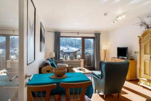 a living room with a blue table and chairs at Almzeit in Farchant