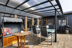 eine Terrasse mit Tisch, Stühlen und Grill in der Unterkunft Happy-Nest in Oberkrämer
