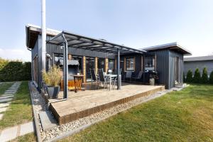 ein Haus mit einer Terrasse mit Tisch und Stühlen in der Unterkunft Happy-Nest in Oberkrämer