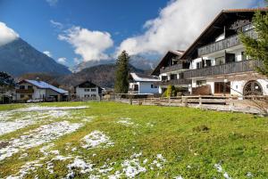 a house in a field with mountains in the background at Almzeit in Farchant