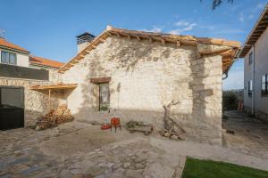 a stone building with a patio in front of it at El Cedro in Abejar