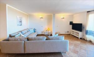 a living room with a couch and a flat screen tv at Villa Ida Isuledda in San Teodoro