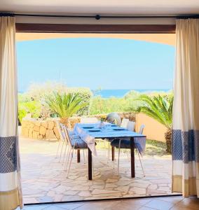 a table and chairs on a patio with a view of the ocean at Villa Ida Isuledda in San Teodoro