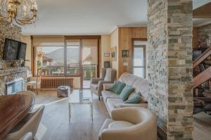 a living room with couches and a stone fireplace at El Cedro in Abejar