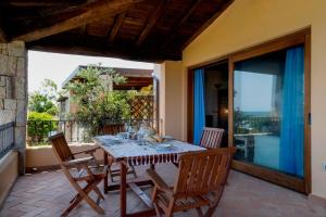 a dining room with a table and chairs on a patio at Villa Ida Isuledda in San Teodoro