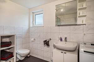 a white bathroom with a sink and a toilet at Zeiser in Pfullendorf +12 photos