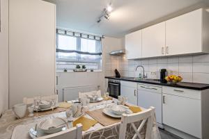 a kitchen with white cabinets and a table with chairs at Zeiser in Pfullendorf