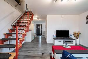 a living room with a staircase and a television at Zeiser in Pfullendorf