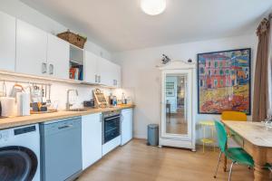a kitchen with white cabinets and a table with chairs at Ferienwohnung im Reiterparadies in Salzhausen