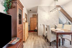 a dining room with a wooden table and white chairs at Gemütliches Appartament in Aldingen +12 photos