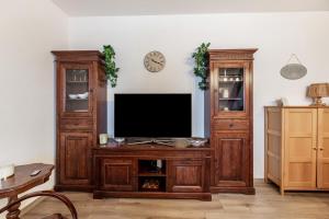 a large wooden entertainment center with a television in a living room at Gemütliches Appartament in Aldingen