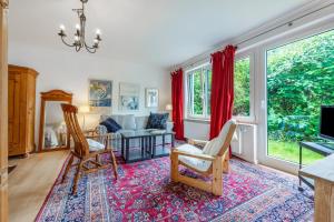 a living room with chairs and a couch and windows at Ferienwohnung im Reiterparadies in Salzhausen