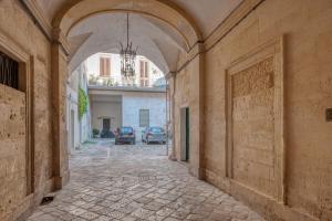 an alley way with an archway in a building at San Leonardo Apartments in Lecce