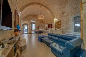 a living room with a blue couch and a brick wall at San Leonardo Apartments in Lecce